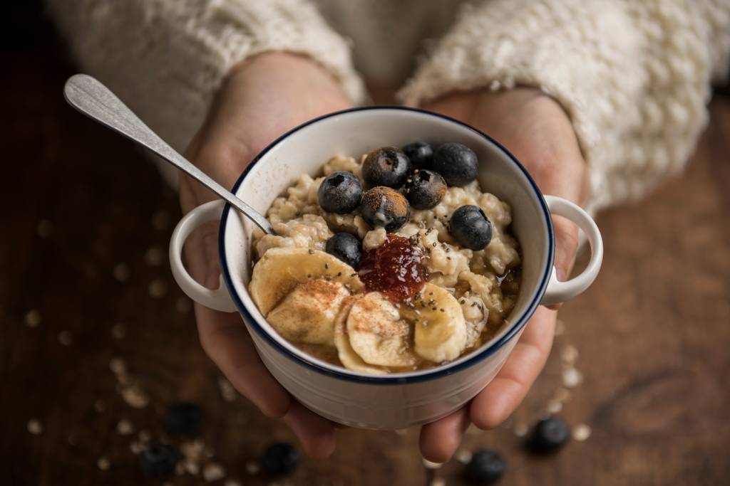 Nackthafer-Test: Eine Frau hält eine Schüssel mit Porridge in der Hand. 