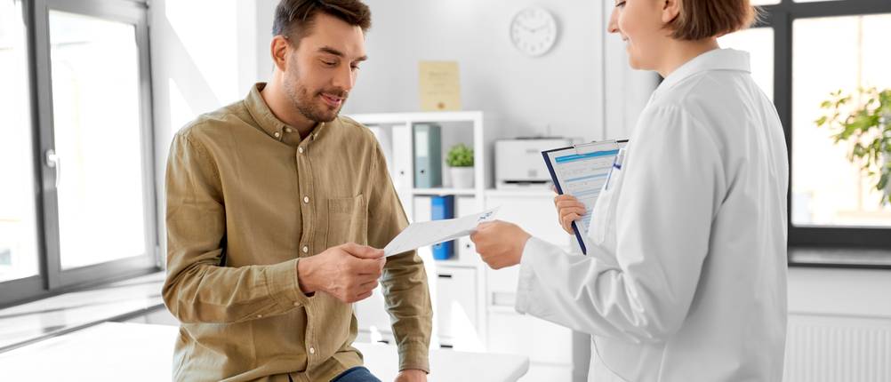 Nadeldrucker-Test: Ärztin überreicht einem Patienten ein Rezept.