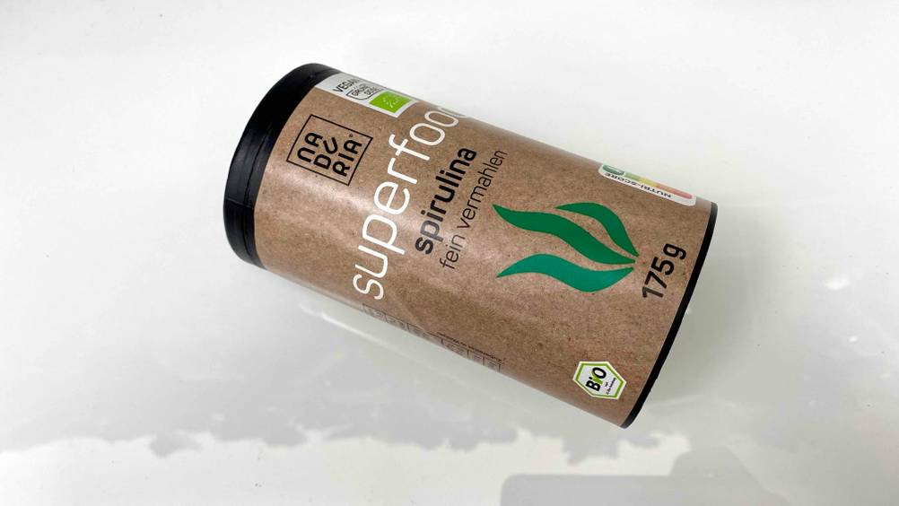 Im Test: Eine Dose Spirulina liegt quer auf einer hellen Fläche.