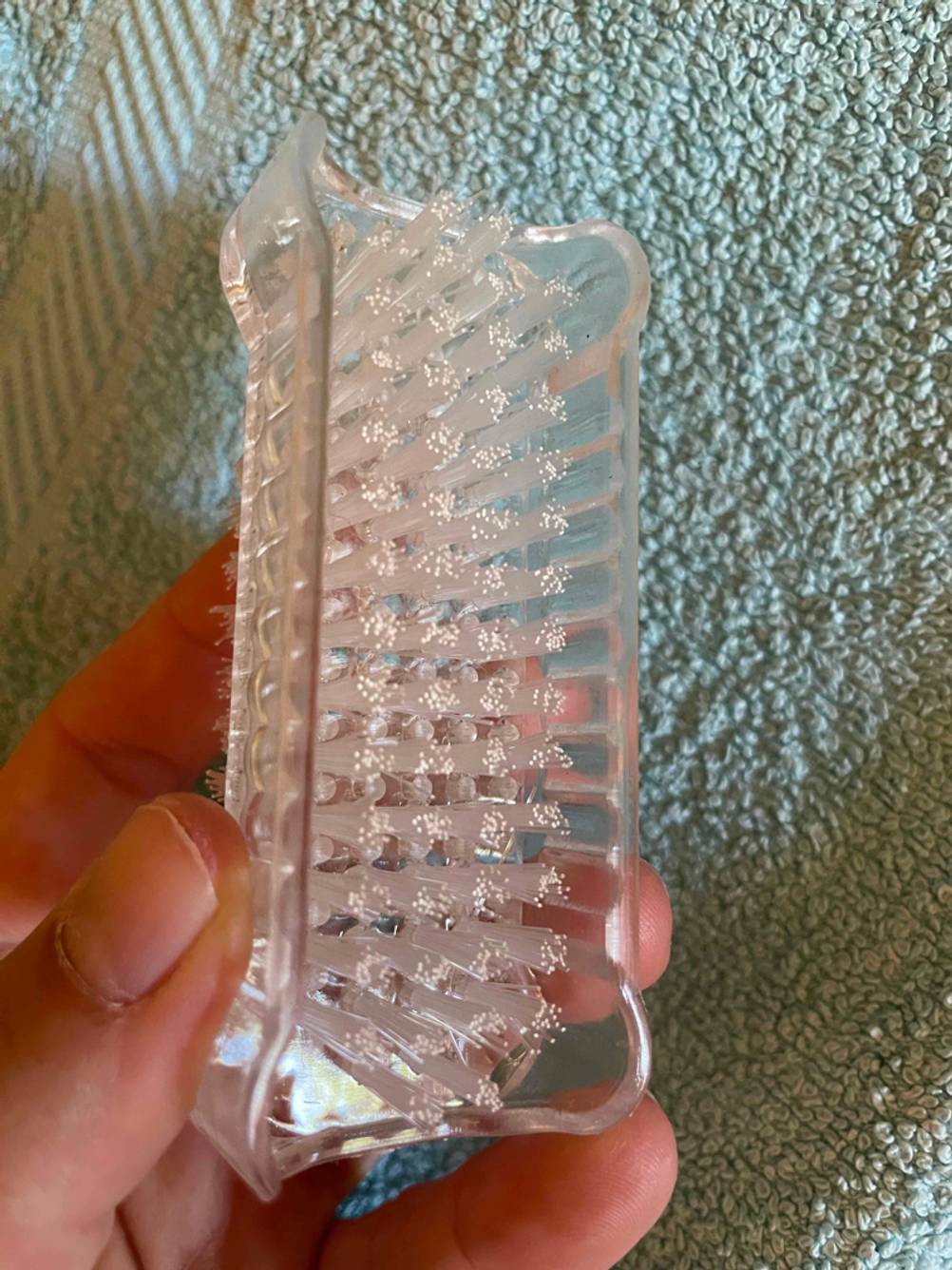 Nahaufnahme der Rückseite der Nagelbürste im Test von einer Hand gehalten.