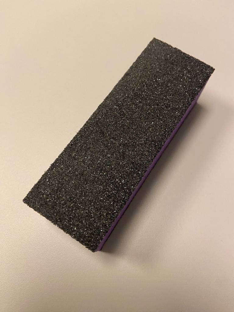 Blick von oben auf die schwarze Fläche eines getesteten Nagelpolierblocks.