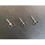 Drei Nagelscheren liegen nebeneinander auf einer Schieferplatte.