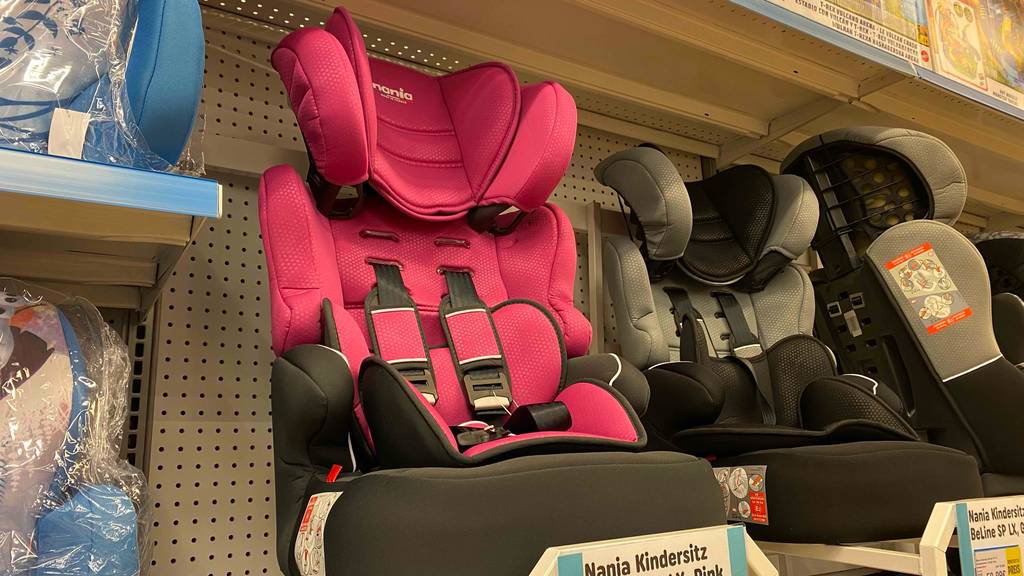 Ein Nania Kindersitz bis 12 Jahre steht zum testen in einem Regal neben anderen Sitzen.