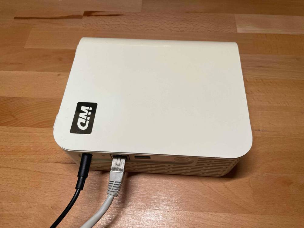 NAS-Festplatten mit 2 TB im Test: Ein weißer NAS-Server von WD liegt mit angesteckten Kabeln auf einem Holzboden.