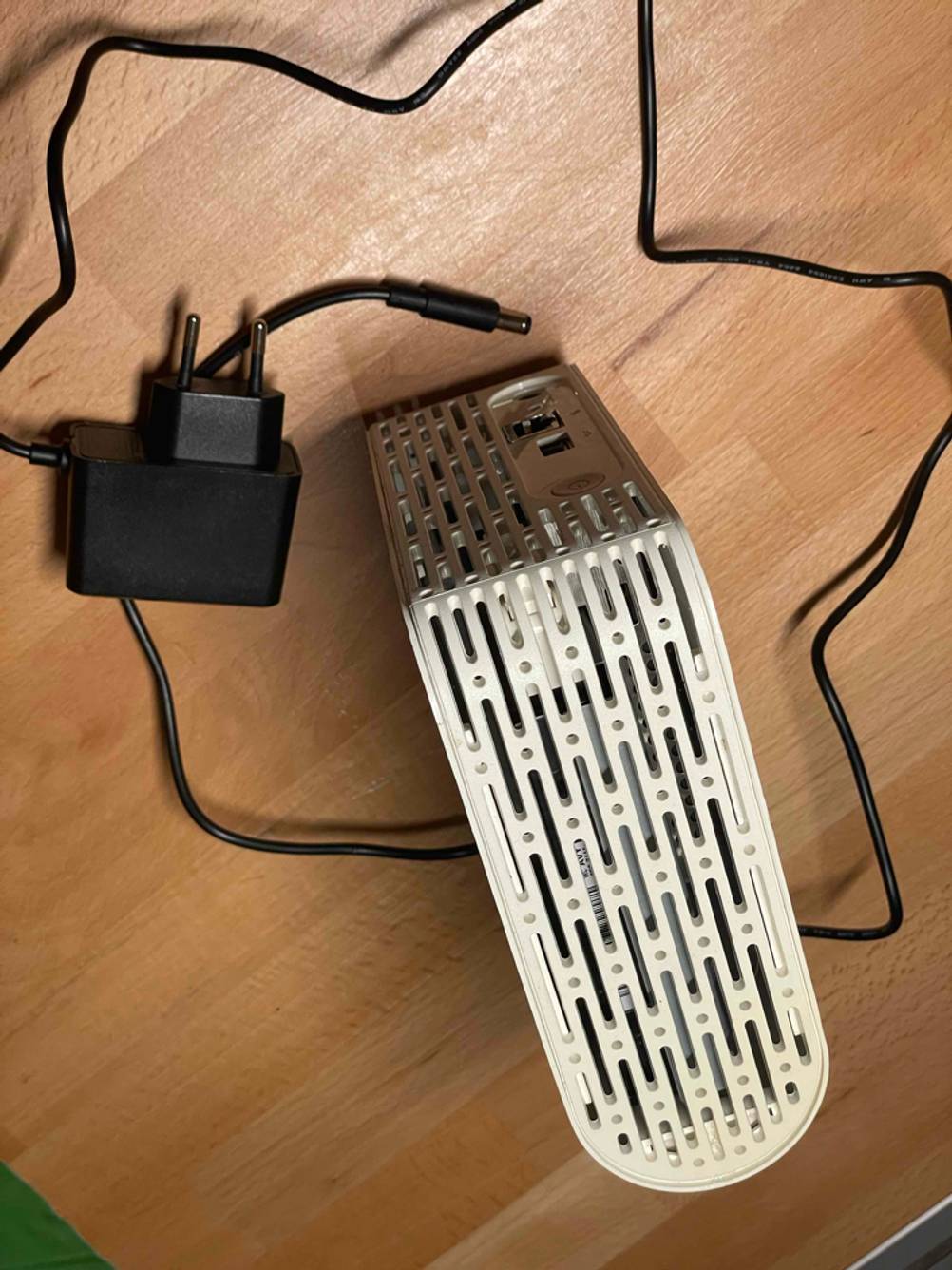 Getestet: Ein NAS-Server von oben auf einer Holzfläche mit einem Stromkabel darum.