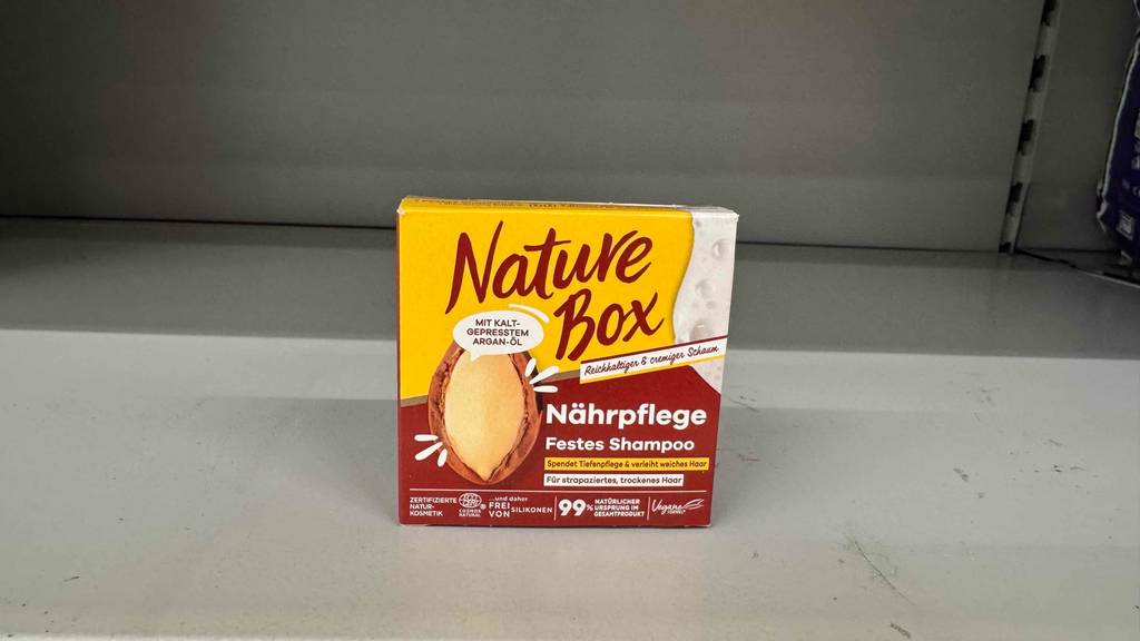 Nature Box festes Shampoo-Test: Die Originalverpackung steht in einem hellen Regalfach.