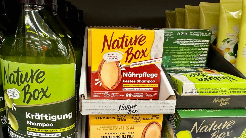 Nature Box festes Shampoo im Test: Mehrere Kartons stehen zwischen anderen Haarpflegeprodukten.