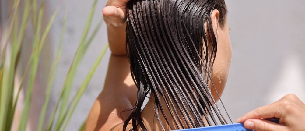 Nature-Box-Spülung-Test: Braunes, nasses Haar wird mit einem blauen Kamm gekämmt.