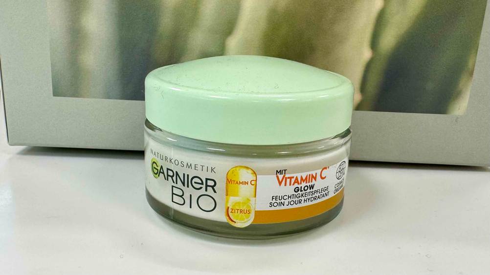 Die getestete Naturkosmetik-Gesichtscreme vor einer grünen Box.