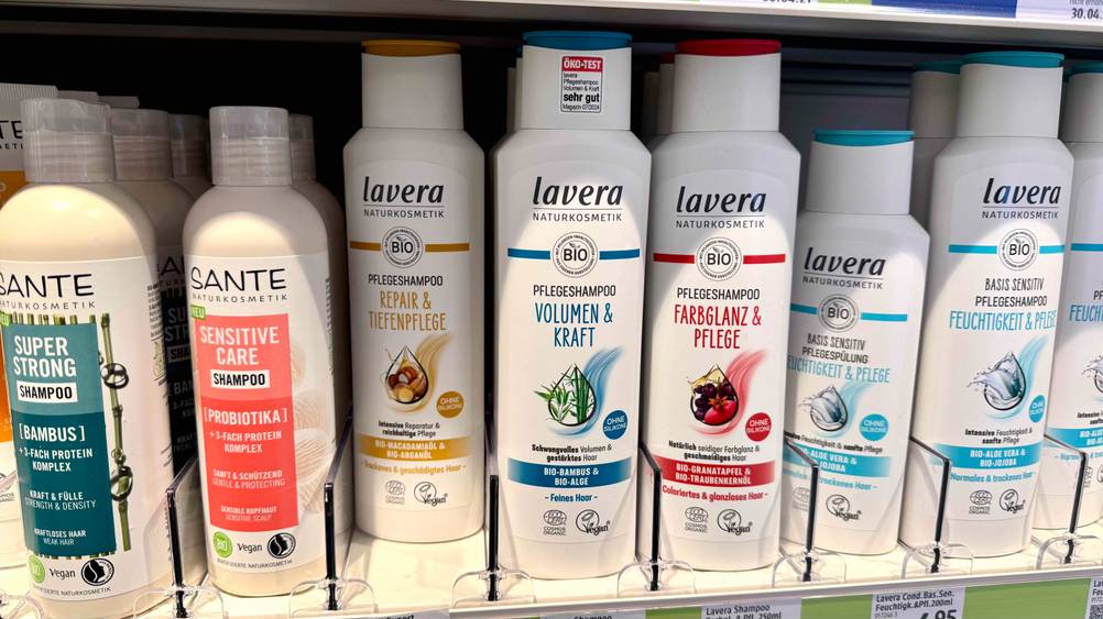 Mehrere Flaschen des getesteten Naturkosmetik-Shampoos stehen in einem Verkaufsregal mit Preisangaben.