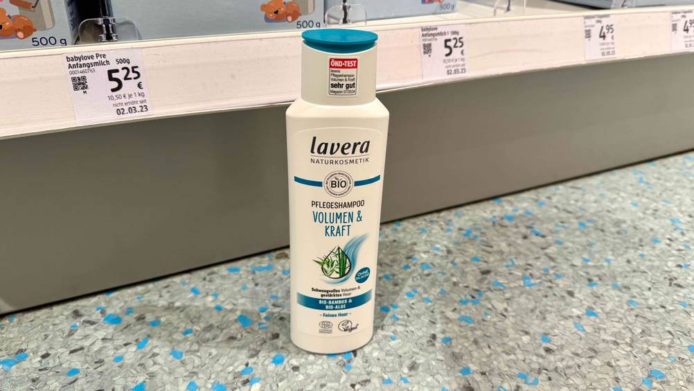 Das getestete Naturkosmetik-Shampoo steht vor einem Verkaufsregal auf dem Boden.