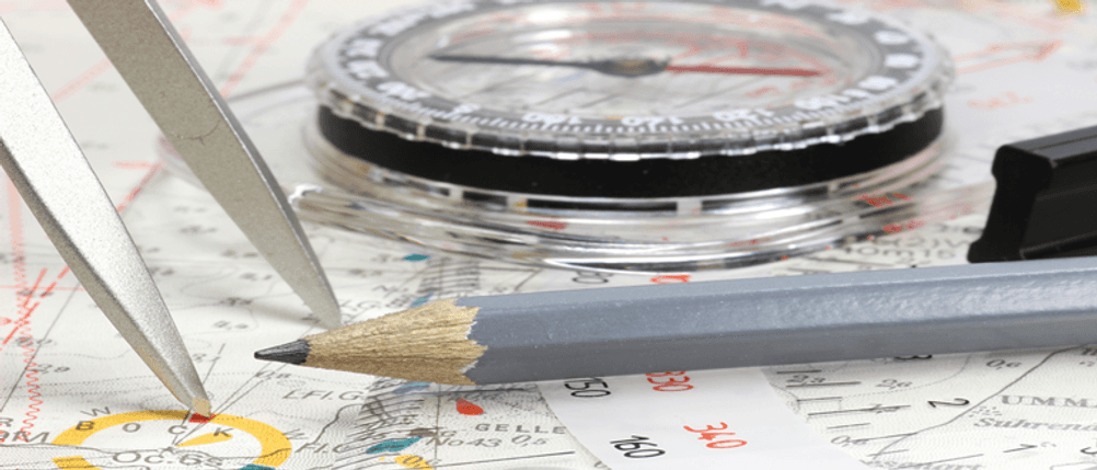Navigationsbesteck im Test: Ein Kompass samt Zirkel und Bleistift auf einer Karte.