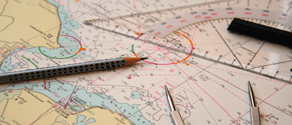 Navigationsbesteck im Test: Zirkel, Dreieck und Bleistift liegen auf einer Karte