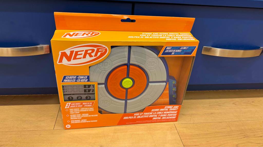 Eine verpackte Nerf-Zielscheibe steht zum testen vor einer blauen Schublade.