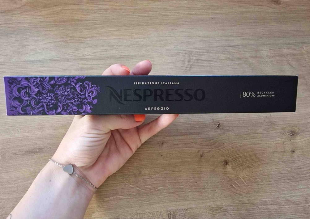 Eine Hand hält eine Stange mit getesteten Nespresso-Kapseln.