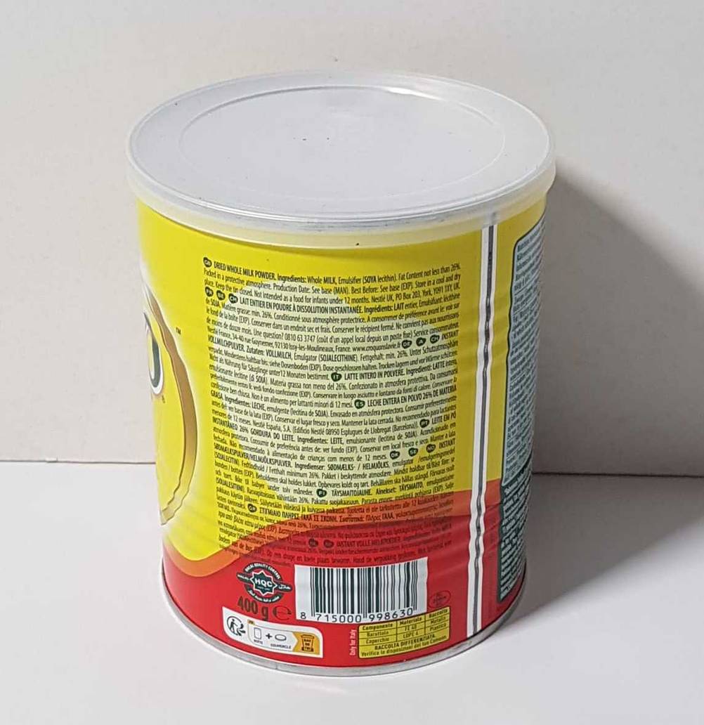 Nahaufnahme der Rückseite einer Dose Milchpulver im Test vor einer hellen Wand.