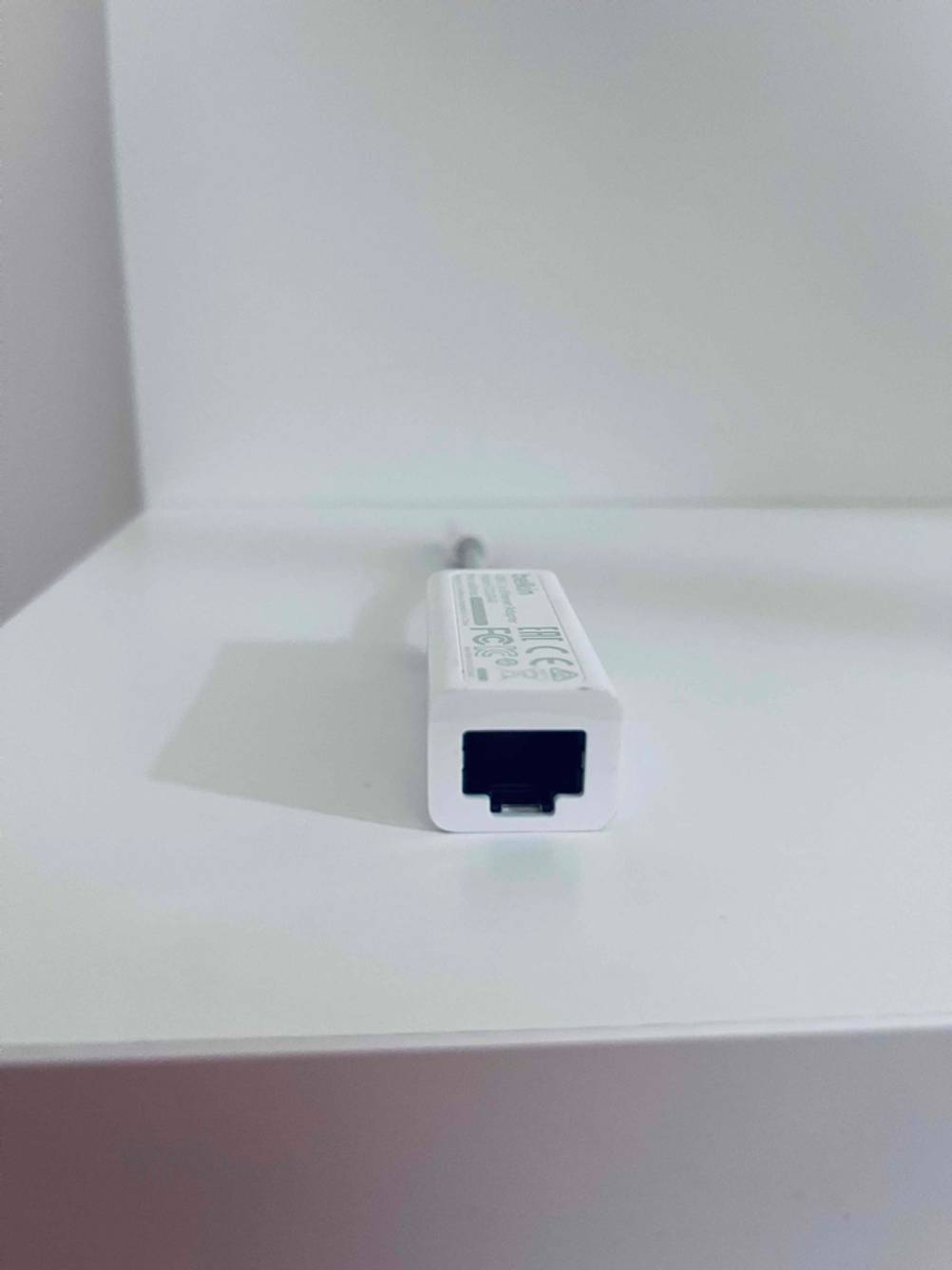 Ein getesteter Netzwerkadapter mit USB-Anschluss befindet sich auf einem Regal. 