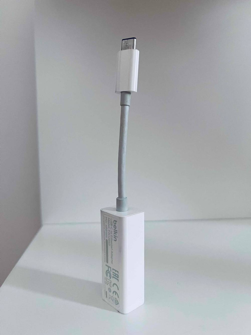 Auf einem Regal befindet sich ein getesteter Netzwerkadapter mit USB-Anschluss der Marke Belkin.