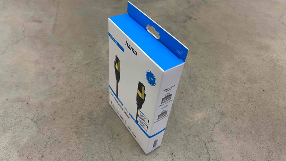 Eine Packung des getesteten Netzwerkkabel (Cat 8) von schräg oben auf einem Betonboden.