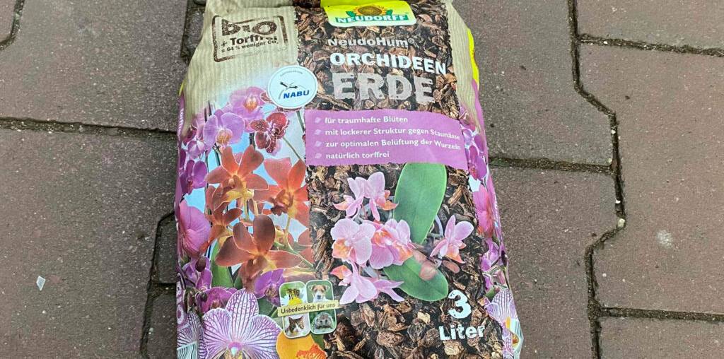 Ein 3-Liter-Kunststoffsack inklusive getesteter Orchideenerde liegt auf einem gepflasterten Boden.
