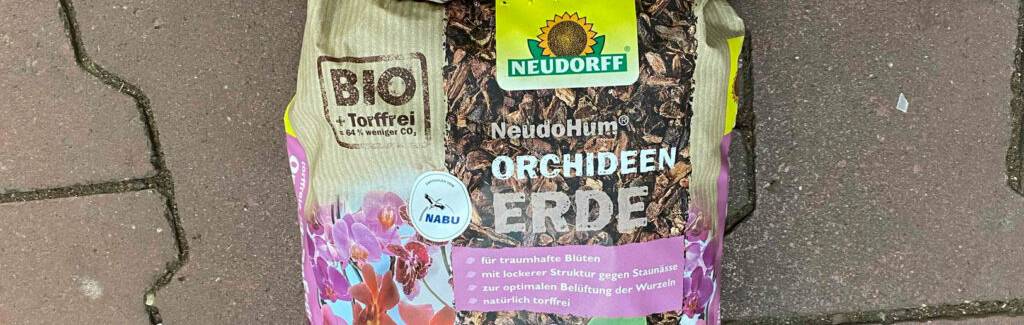 Orchideenerde im Test: Detailansicht eines 3-Liter-Kunststoffsacks, der auf einem gepflasterten Boden liegt.