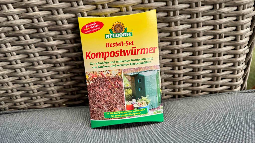 Ein Set Kompostwürmer lehnt zum testen an eine Rattanfläche.
