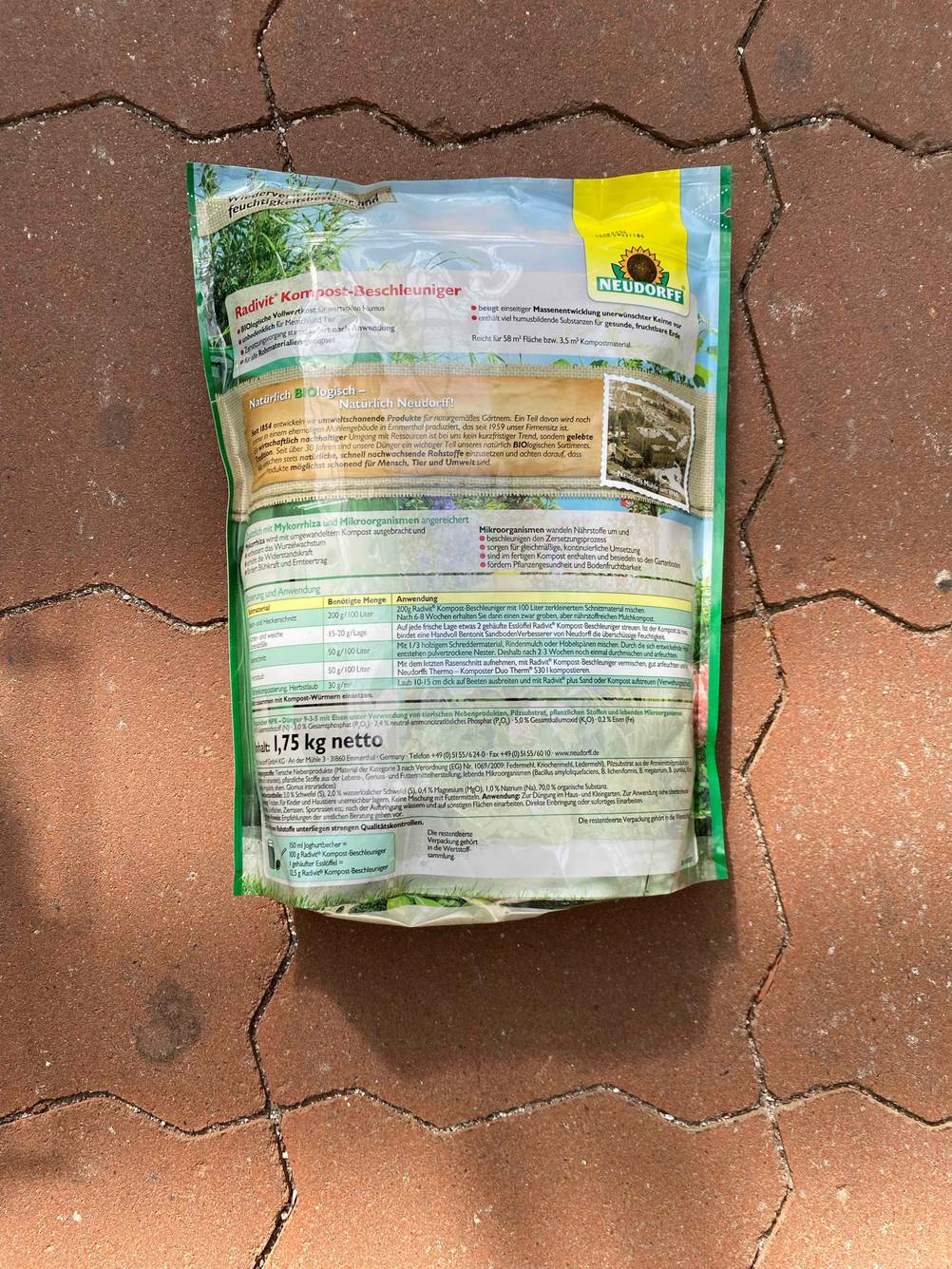 Getestet: Rückseite einer Packung Kompostbeschleunigers auf einem Steinboden.