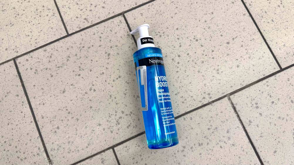 Neutrogena-Gesichtsreinigung getestet: Eine Flasche von oben auf einem Fließenboden liegend.