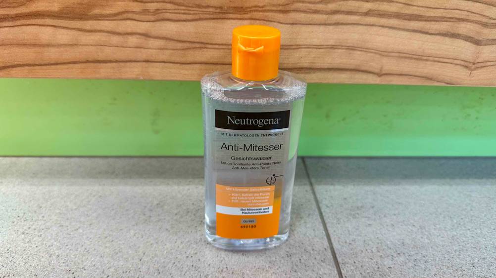 Vor einer Holzwand steht eine Flasche des Neutrogena-Gesichtswasser im Test auf dem Boden.