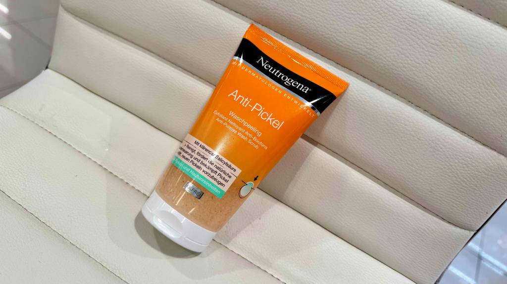 Eine Tube Neutrogena-Peeling liegt zum testen auf einem weißen Ledersessel.
