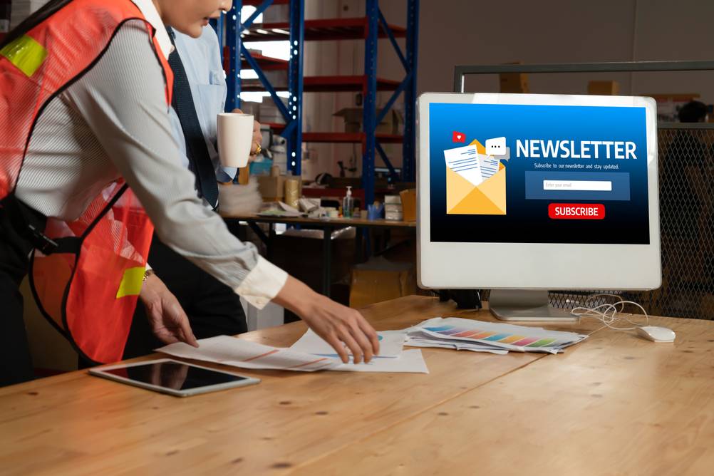 Newsletter-Software im Test: Frau mit Warnweste vor einem Computer, auf dem ein Newsletter-Subscriber geöffnet ist.
