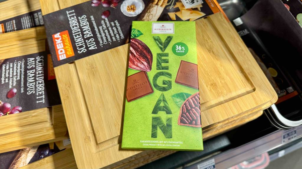 Eine vegane Schokolade im Test liegt auf einem Holzbrett.