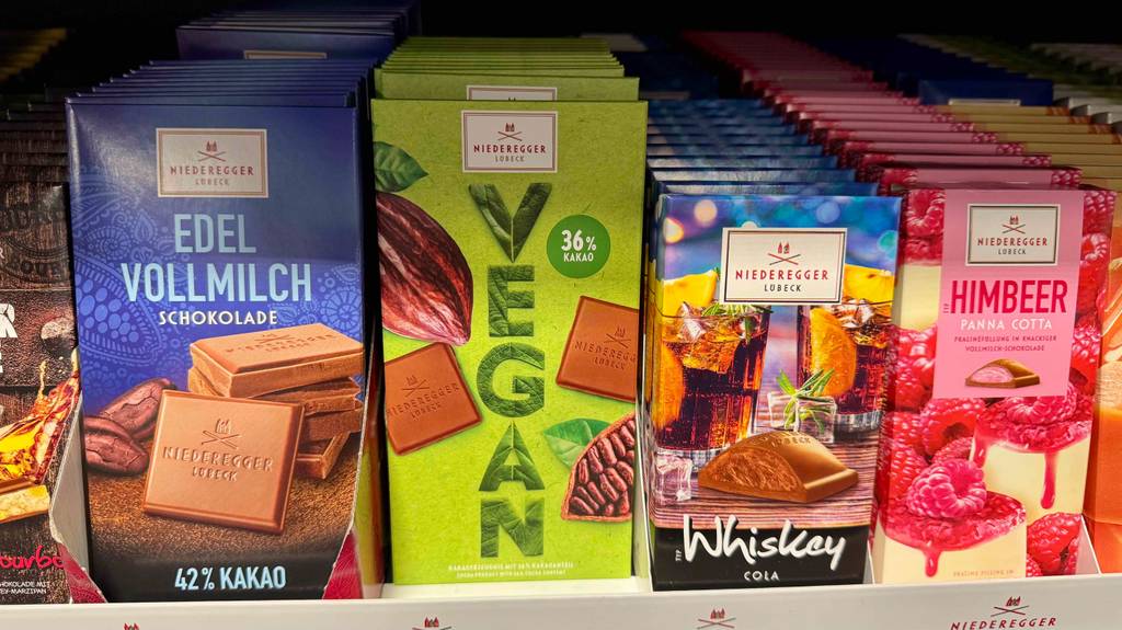 Getestet: Eine vegane Schokolade steht neben anderen Schokoladen in einem Verkaufsregal.