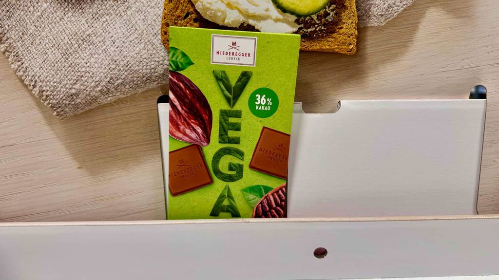 Im Test: Eine vegane Schokolade steht in einem Regal.