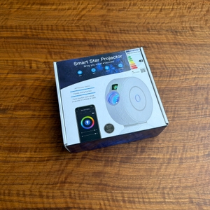 Der Karton vom Nigecue-Sternenhimmel-Projektor HR-002 liegt auf einem Tisch.