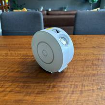 Der Nigecue-Sternenhimmel-Projektor HR-002 steht auf einem Holztisch.