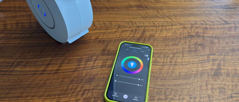 Ein Handy mit der App liegt neben dem Nigecue-Sternenhimmel-Projektor HR-002.