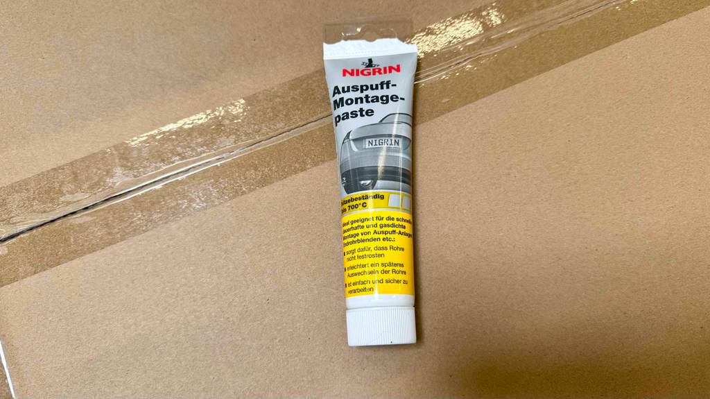Auf der Vorderseite einer Tube Auspuff-Montagepaste im Test stehen Informationen zur Funktion.