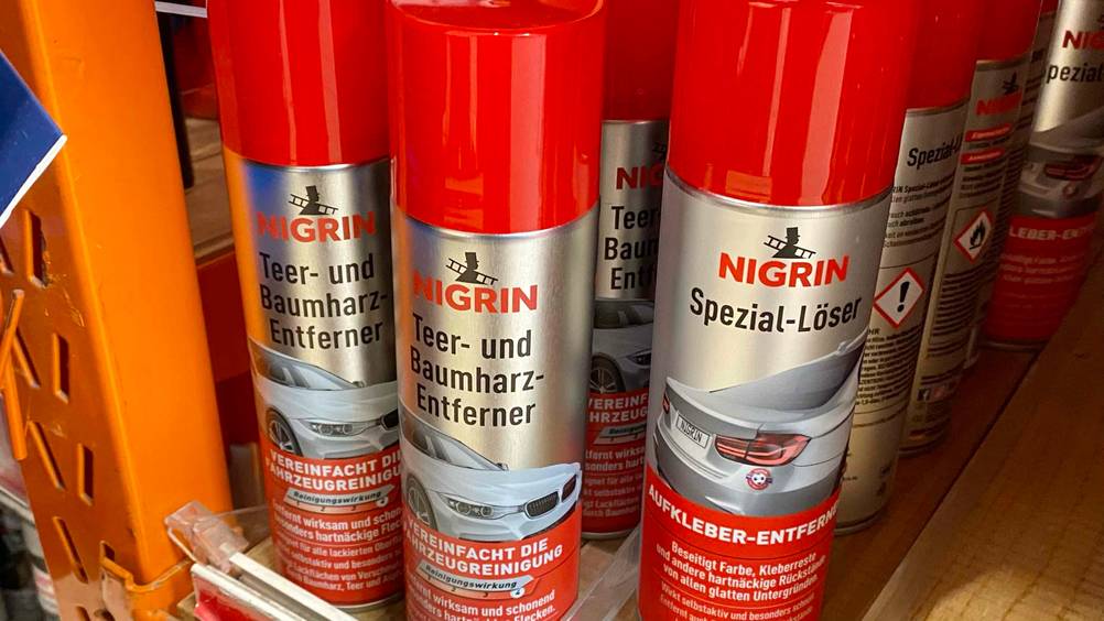 Im Test: Mehrere Teerentferner und andere Produkte in einem Regal.