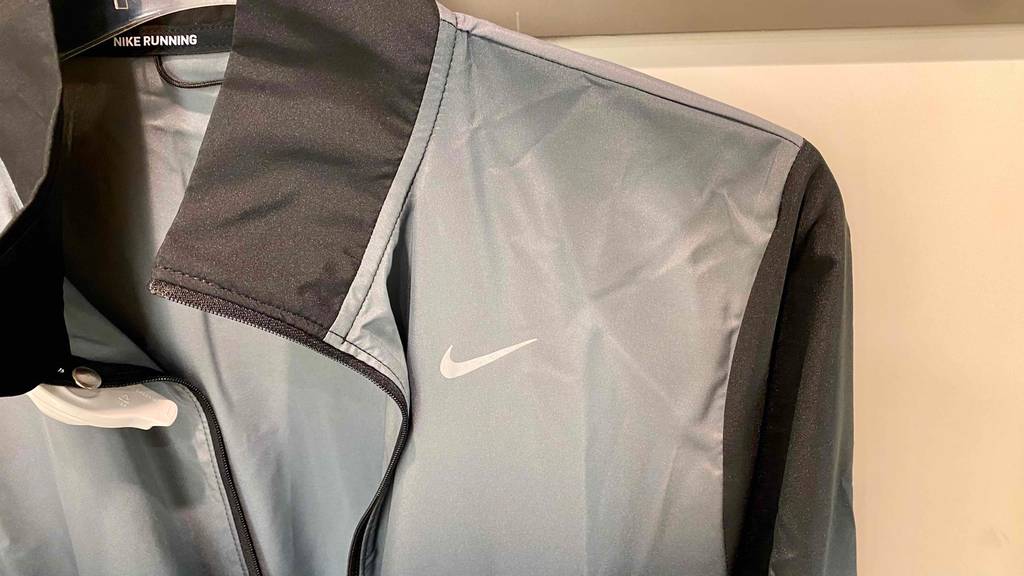 Kragen einer getesteten Damen-Laufjacke von Nike in Grau/Schwarz.