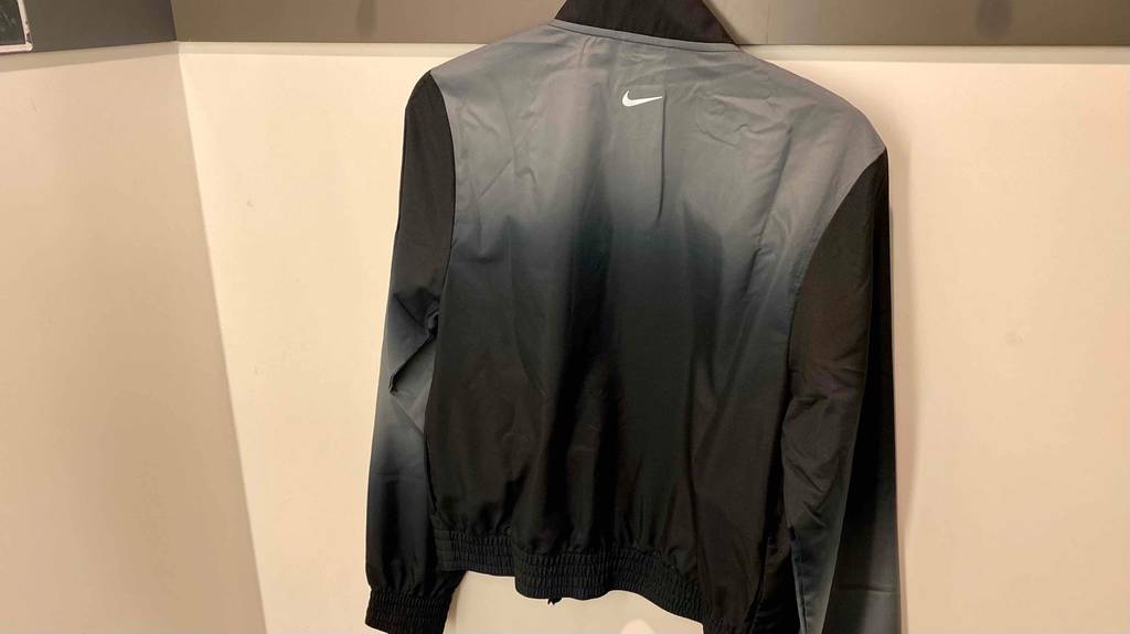 Rückseite einer getesteten Damen-Laufjacke von Nike, hängend an einer Wand.