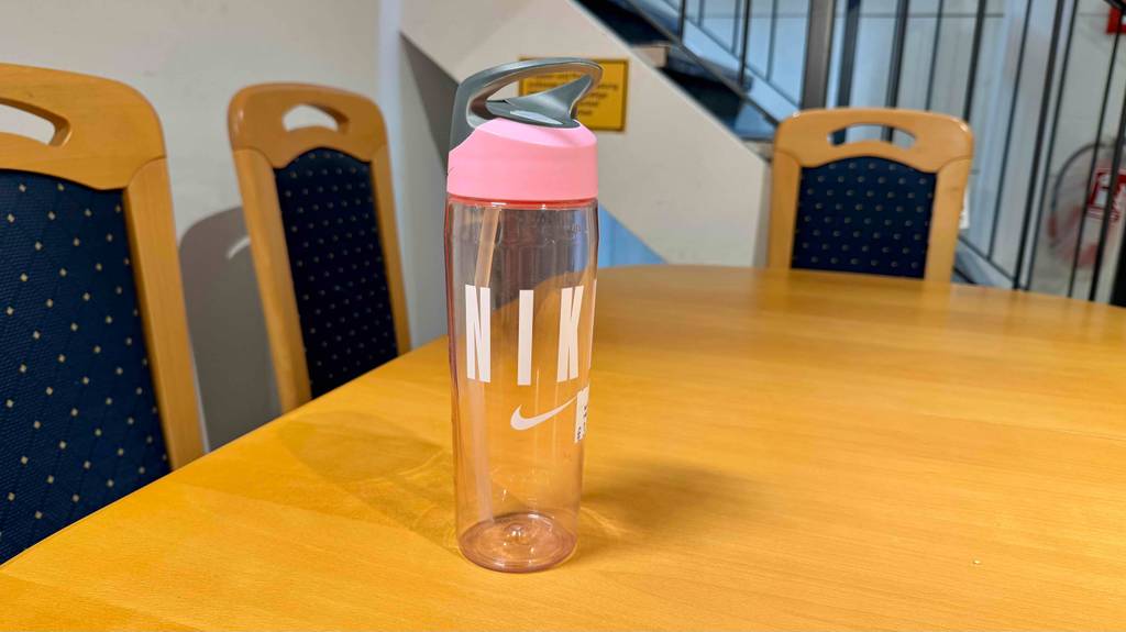 Trinkflasche mit Strohhalm im Test: Eine Flasche mit rosa Deckel steht auf einem Holztisch.