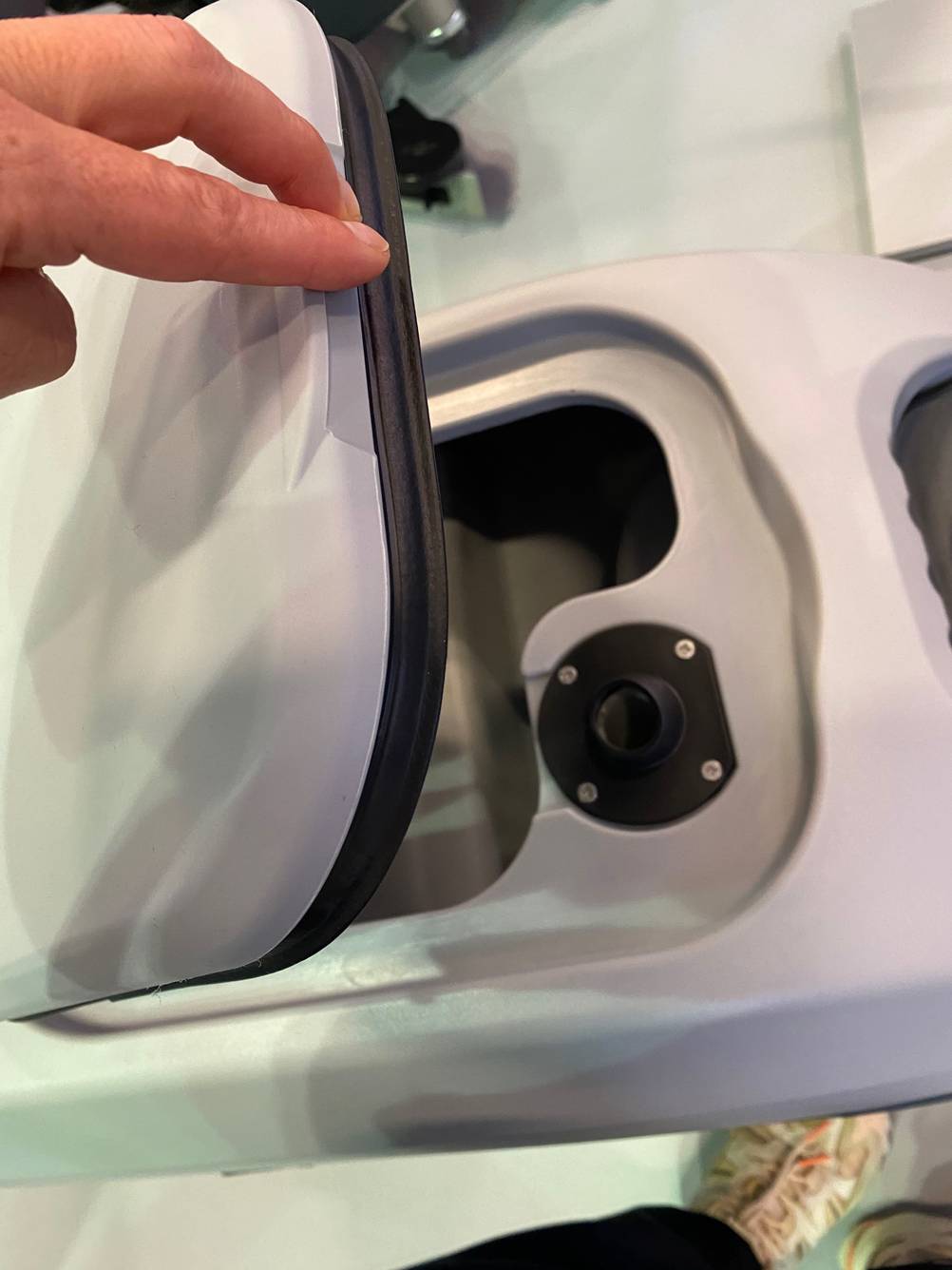 Detailansicht des von Hand geöffneten Wasserbehälters einer hellgrauen Scheuersaugmaschine im Test.