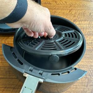 Eine Hand hebt einen Einsatz aus dem Behälter der Ninja AF100EU.