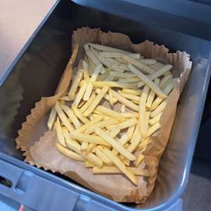 Pommes liegen in der Ninja Foodi MAX AF400EUCP in Backpapier