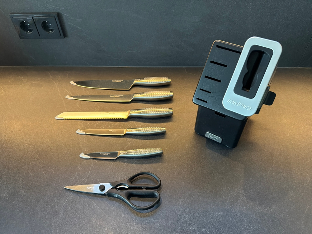 Die Messer und die Schere aus dem Ninja-Foodi-Messerblock liegen neben dem Messerblock.