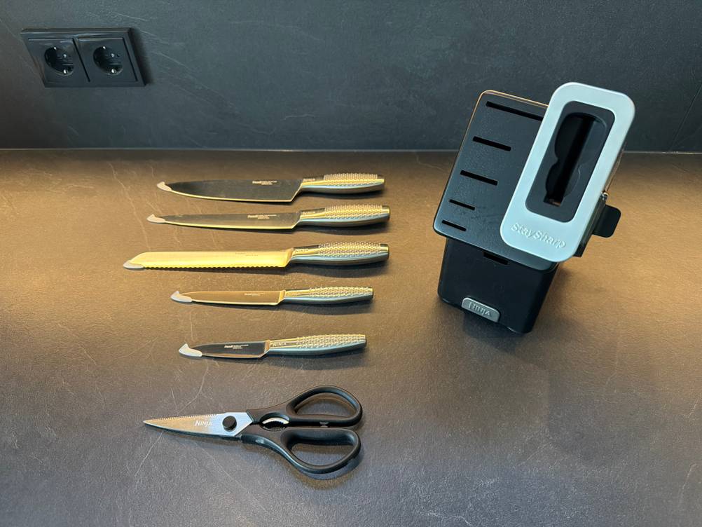Die Messer und die Schere aus dem Ninja-Foodi-Messerblock liegen neben dem Messerblock.