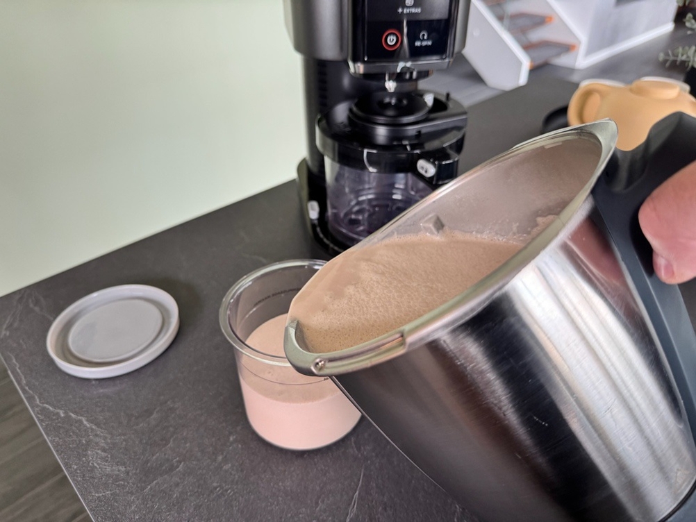 Aus einem Topf wird eine Eismischung in einen Eisbehälter der Ninja NC300EU gefüllt.