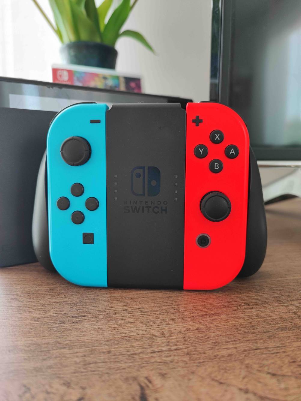 Im Test: Ein Nintendo-Switch-Controller auf einer Holzfläche vor einem Monitor.