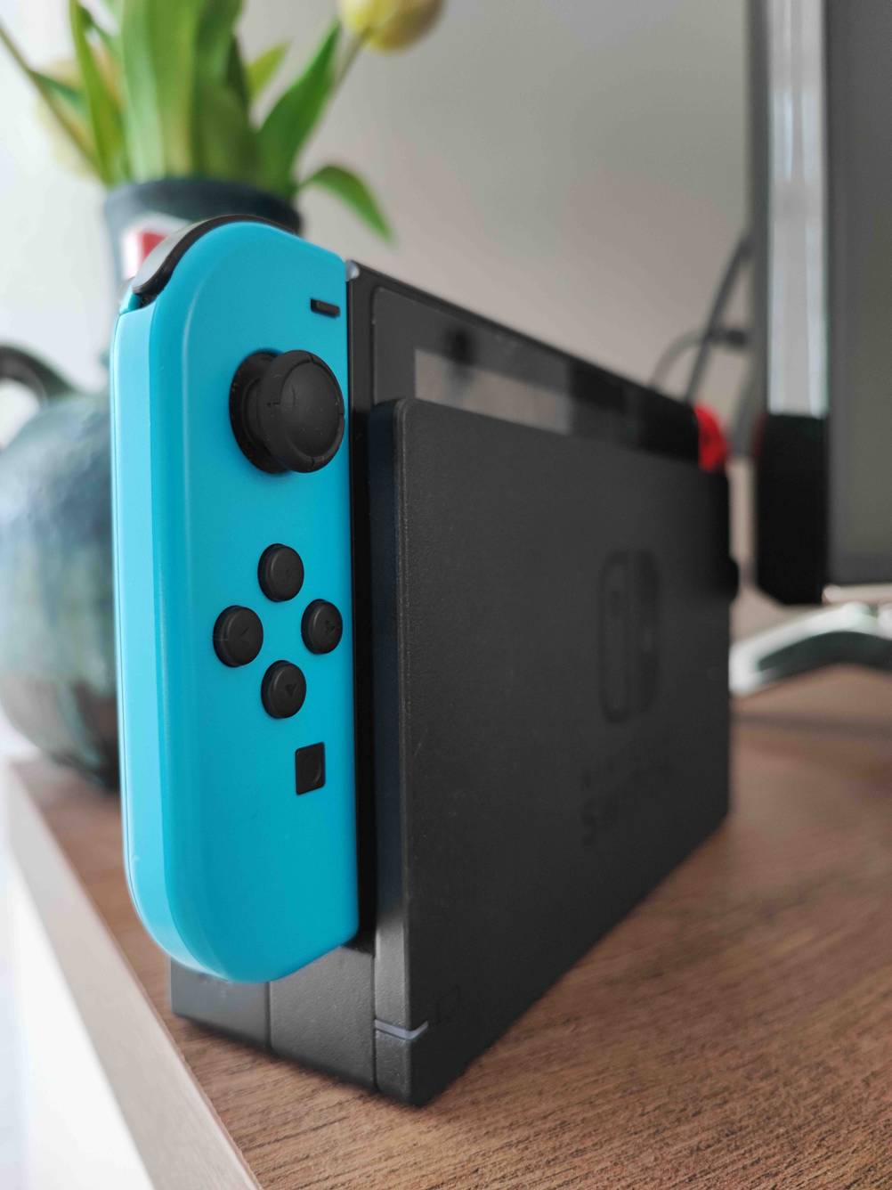 Ein blauer Nintendo Switch Controller steckt getestet in der Konsole.